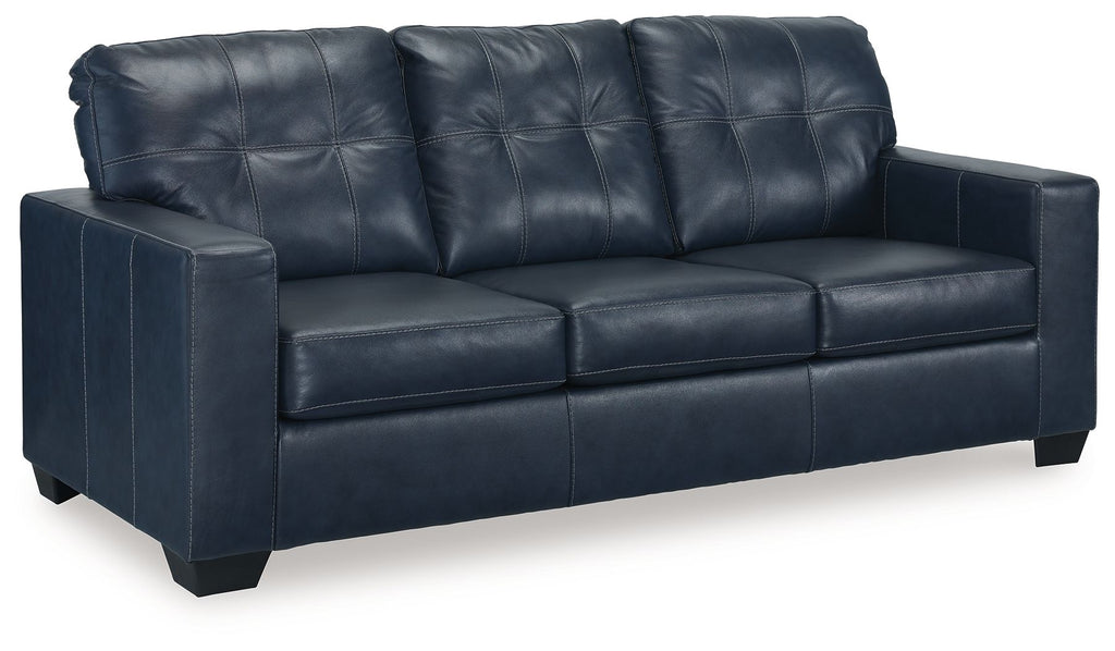 Navy blue sofa sleeper with tufted back, padded arms, and square seat cushions