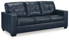 Navy blue sofa sleeper with tufted back, padded arms, and square seat cushions