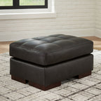 Dark brown upholstered ottoman with tufted lid, square base, dark wooden block feet
