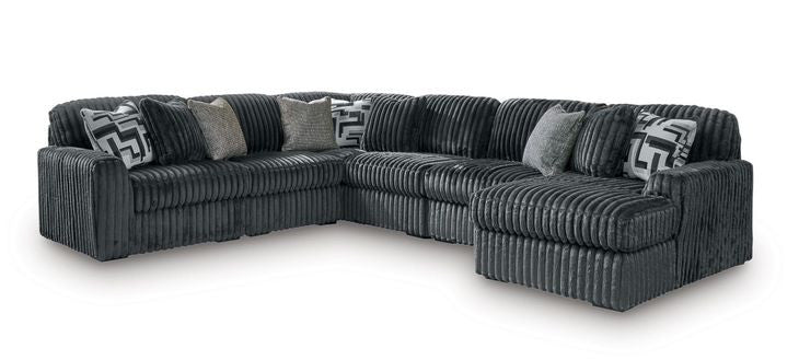Dark gray corduroy sectional sofa with corner chaise and patterned accent pillows