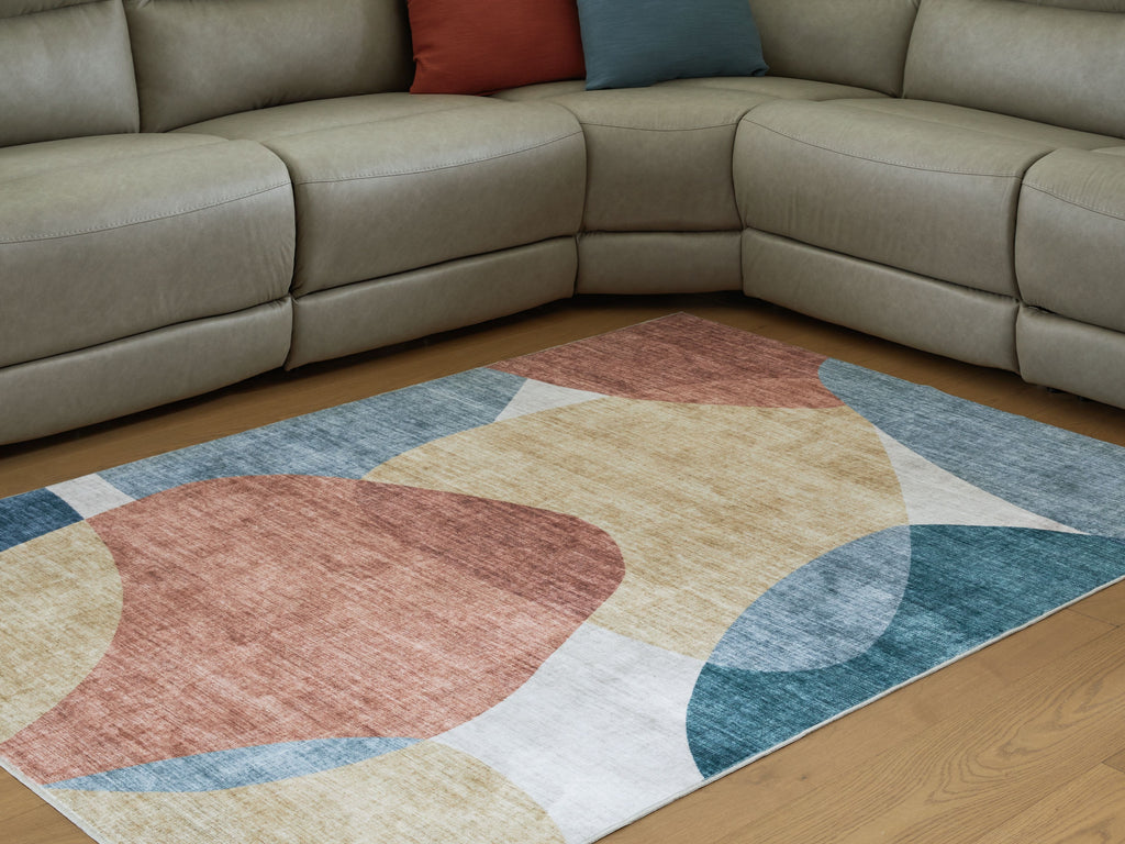 Geometric washable rug with blue, coral, beige, and gray abstract circles and blocks