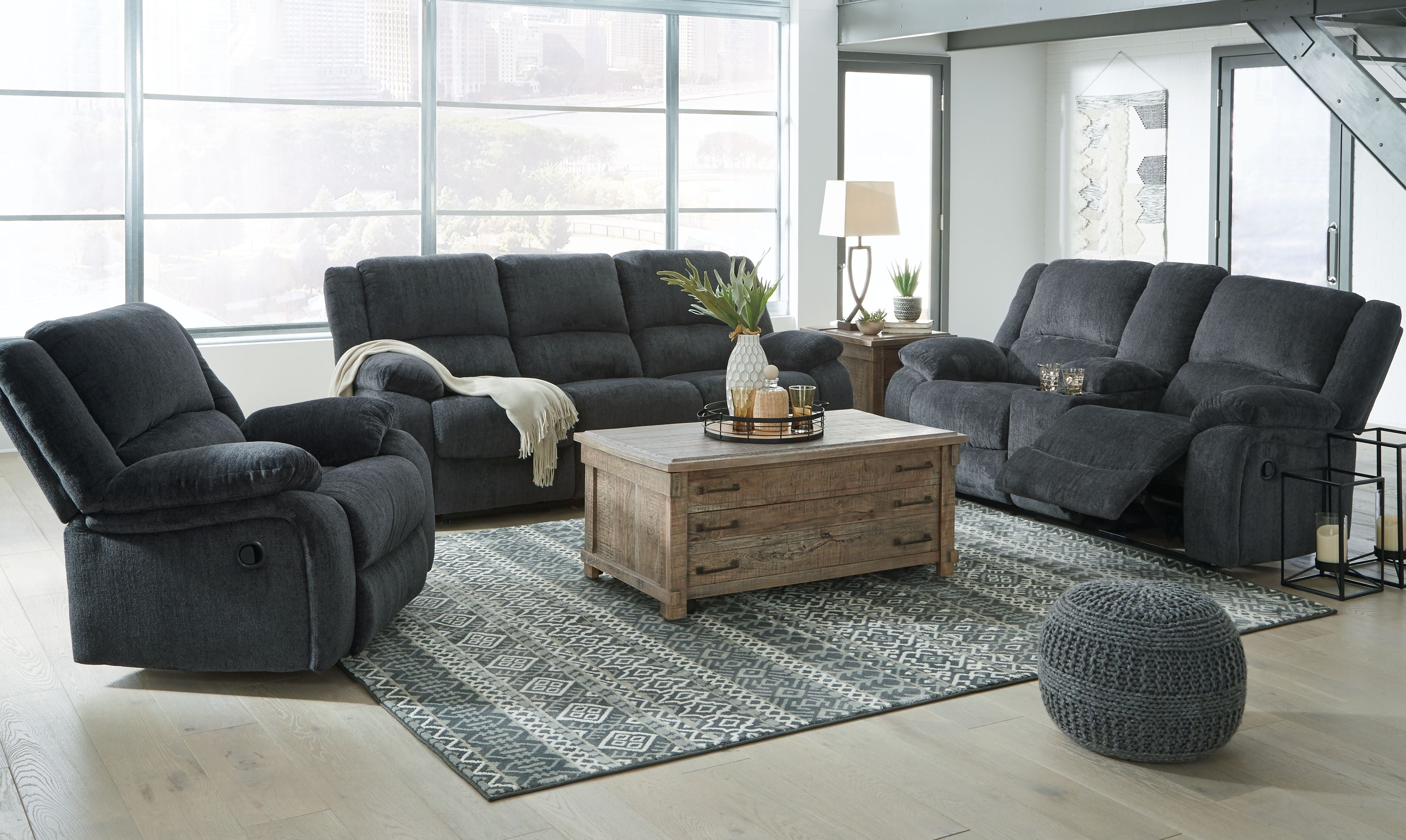 Reclining living room set with multiple dark gray recliners, loveseat, and ottoman