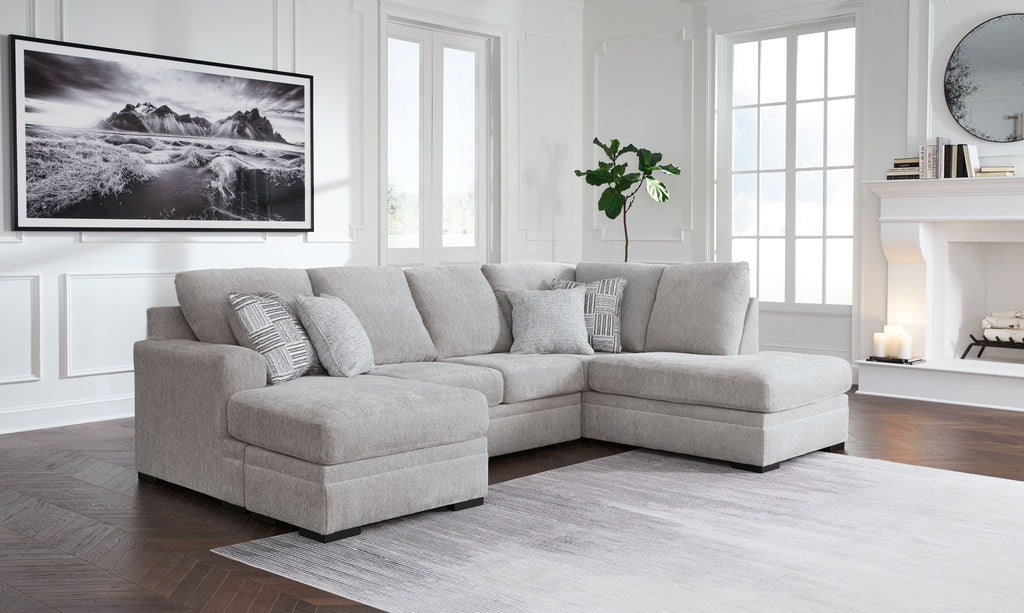 Gray sectional sofa with chaise, four back pillows, low arms, tufted seat cushions
