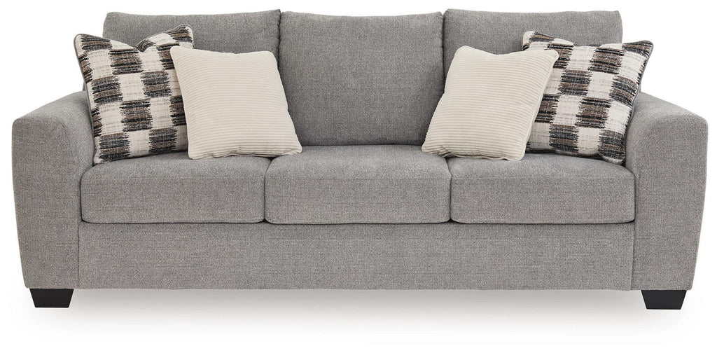 Gray fabric sofa with three seat cushions, patterned and cream throw pillows