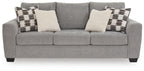 Gray fabric sofa with three seat cushions, patterned and cream throw pillows