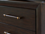 Dark brown dresser drawer with brass bar pull and drawer edge