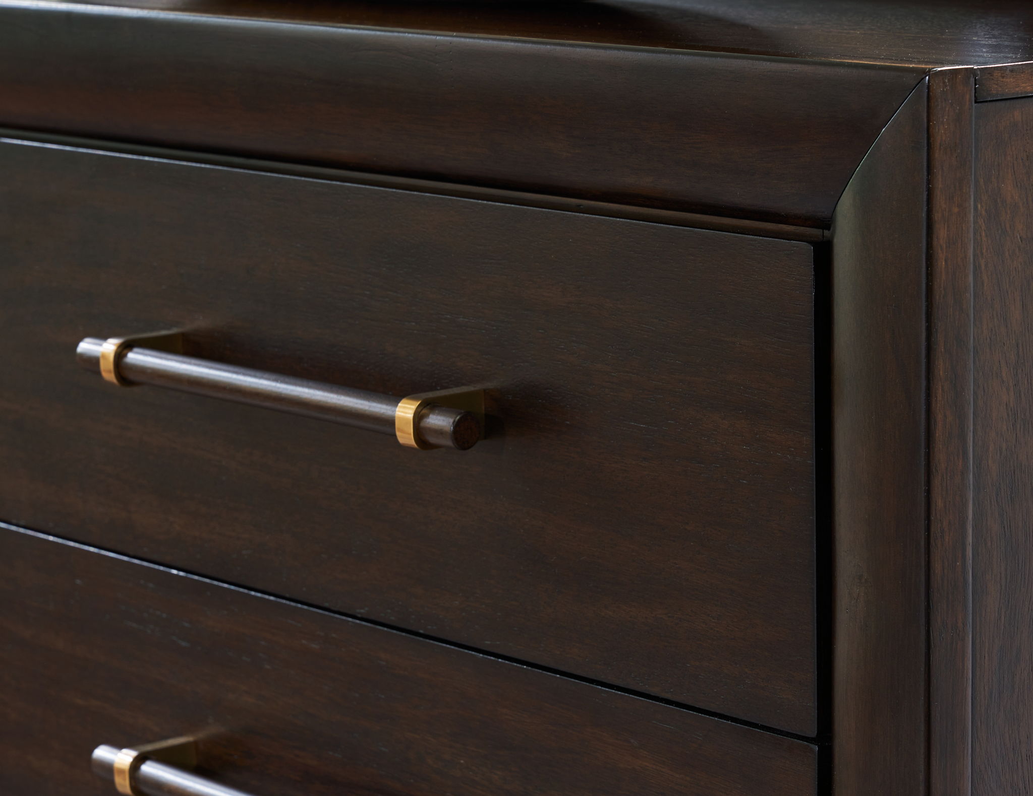 Dark brown dresser drawer with brass bar pull and drawer edge