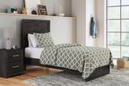 Panel bed with dark wood headboard and footboard, patterned duvet and pillows