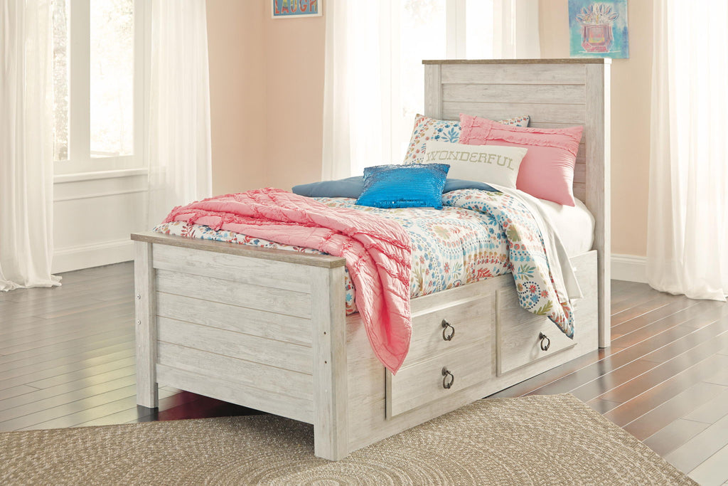 Beige panel bed with two drawers, slatted headboard, topped with colorful patterned bedding