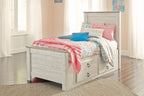 Beige panel bed with two drawers, slatted headboard, topped with colorful patterned bedding