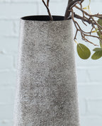 Ceramic vase in light gray speckled finish with flared open top and smooth sides.
