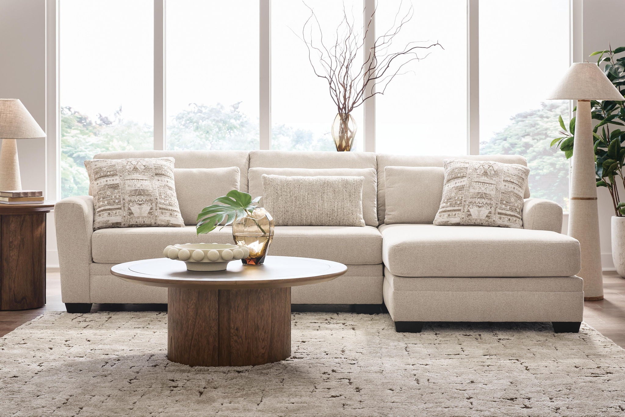 Light beige sectional sofa with chaise, square arms, and solid and patterned pillows