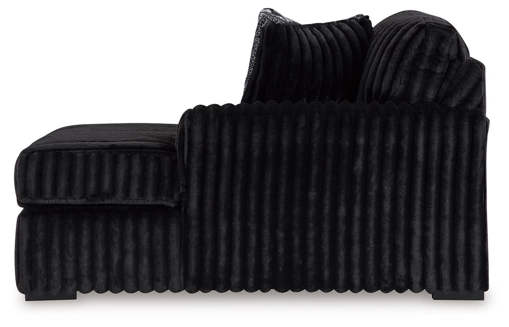Black ribbed corner chaise with rounded arms and a low backrest