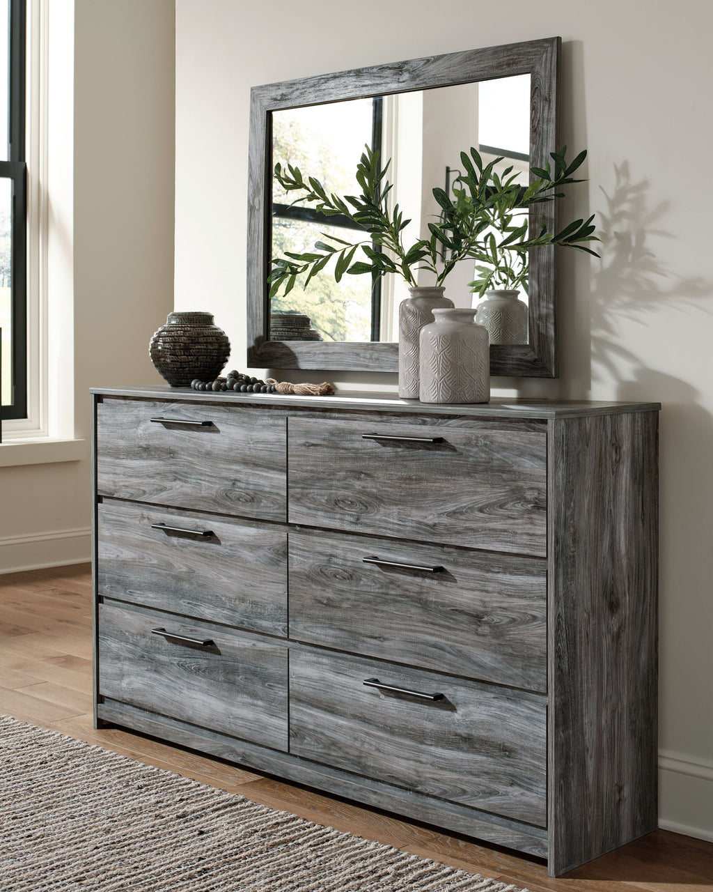 Dark gray dresser with rectangular mirror and six drawers, wood grain finish