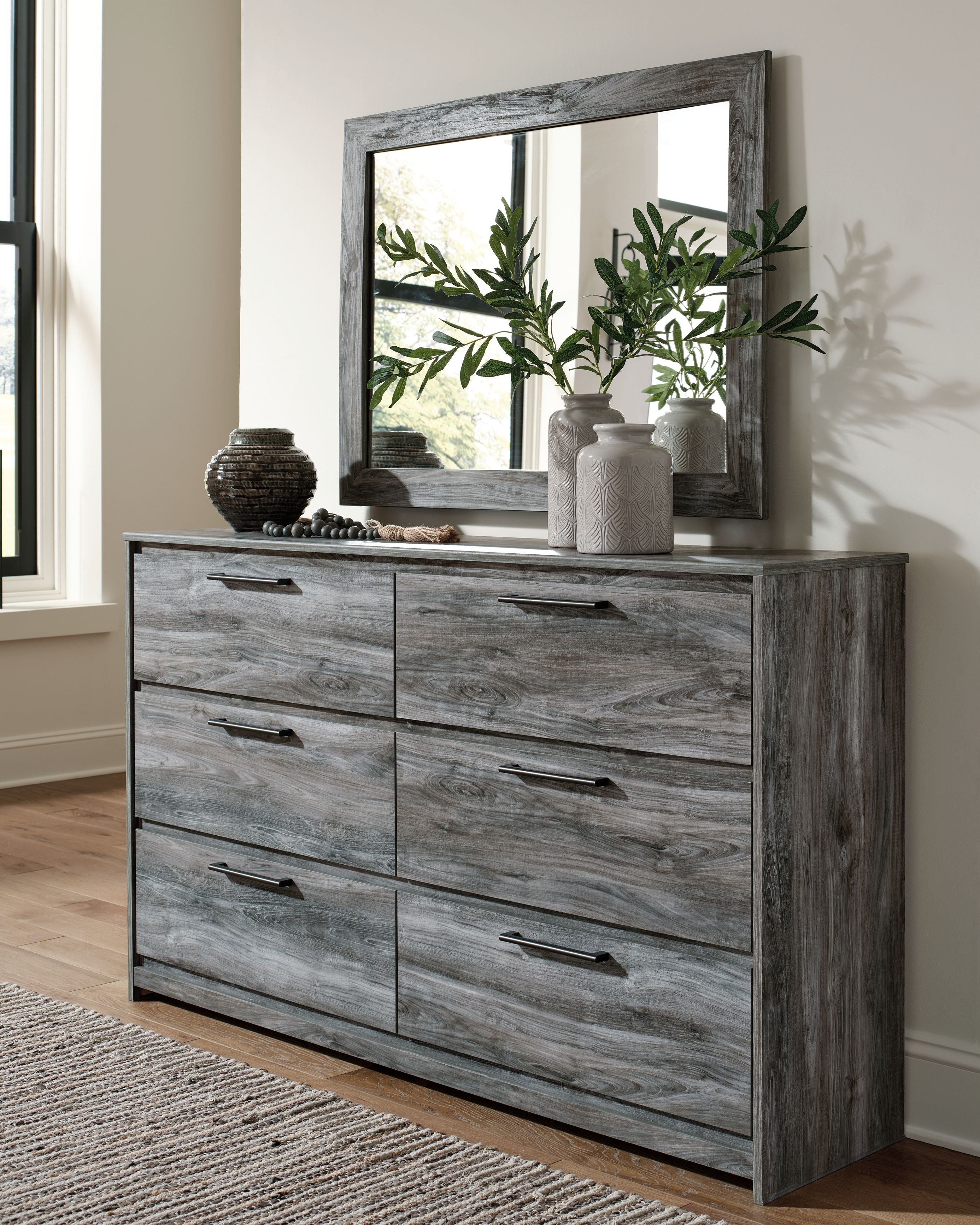Dark gray dresser with rectangular mirror and six drawers, wood grain finish