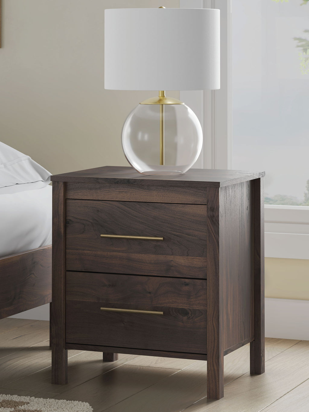 Calverson Night Stand with two drawers and brass bar pulls next to a lamp