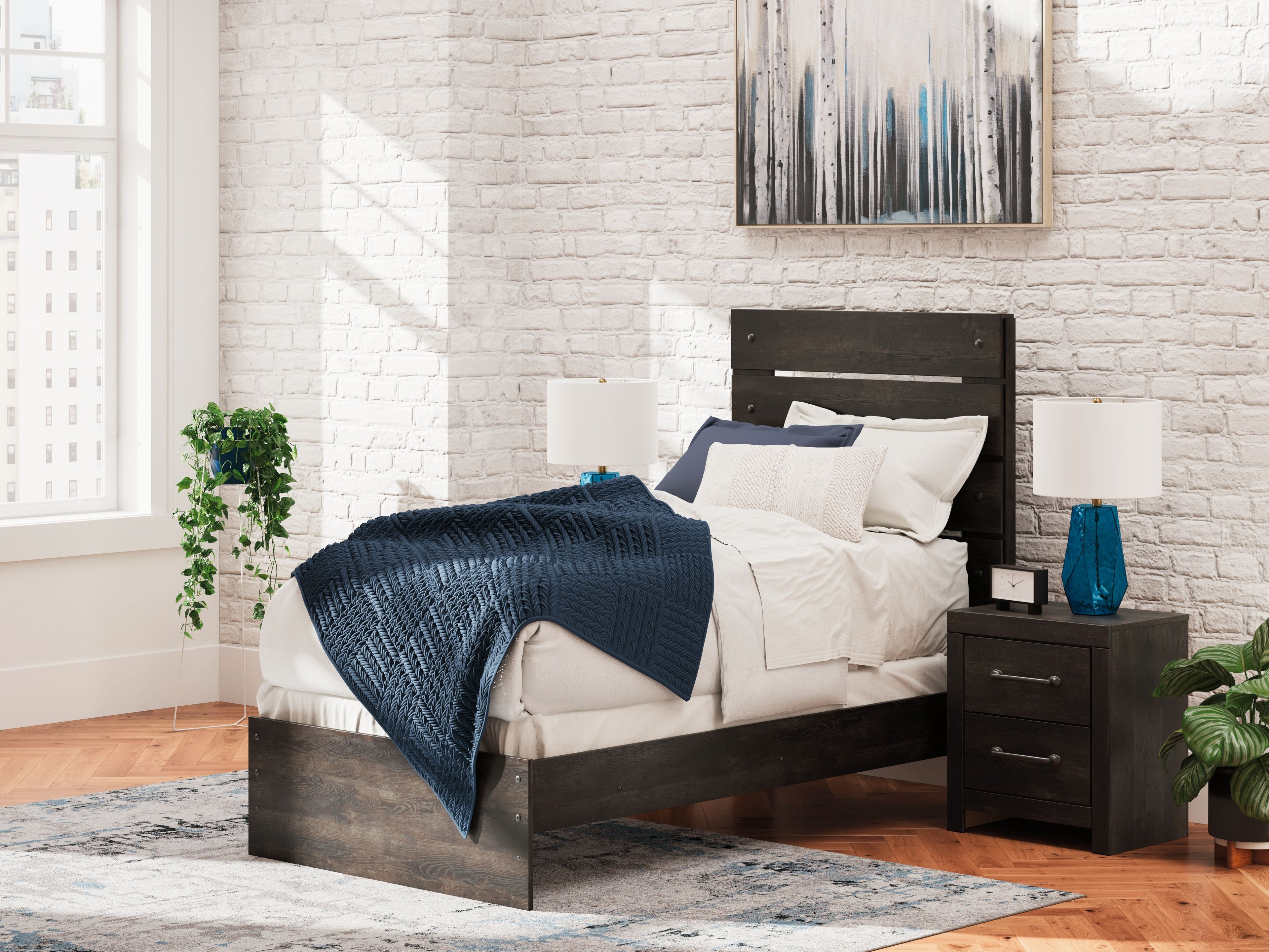 Dark gray panel bed with headboard and footboard, dressed with white bedding and pillow