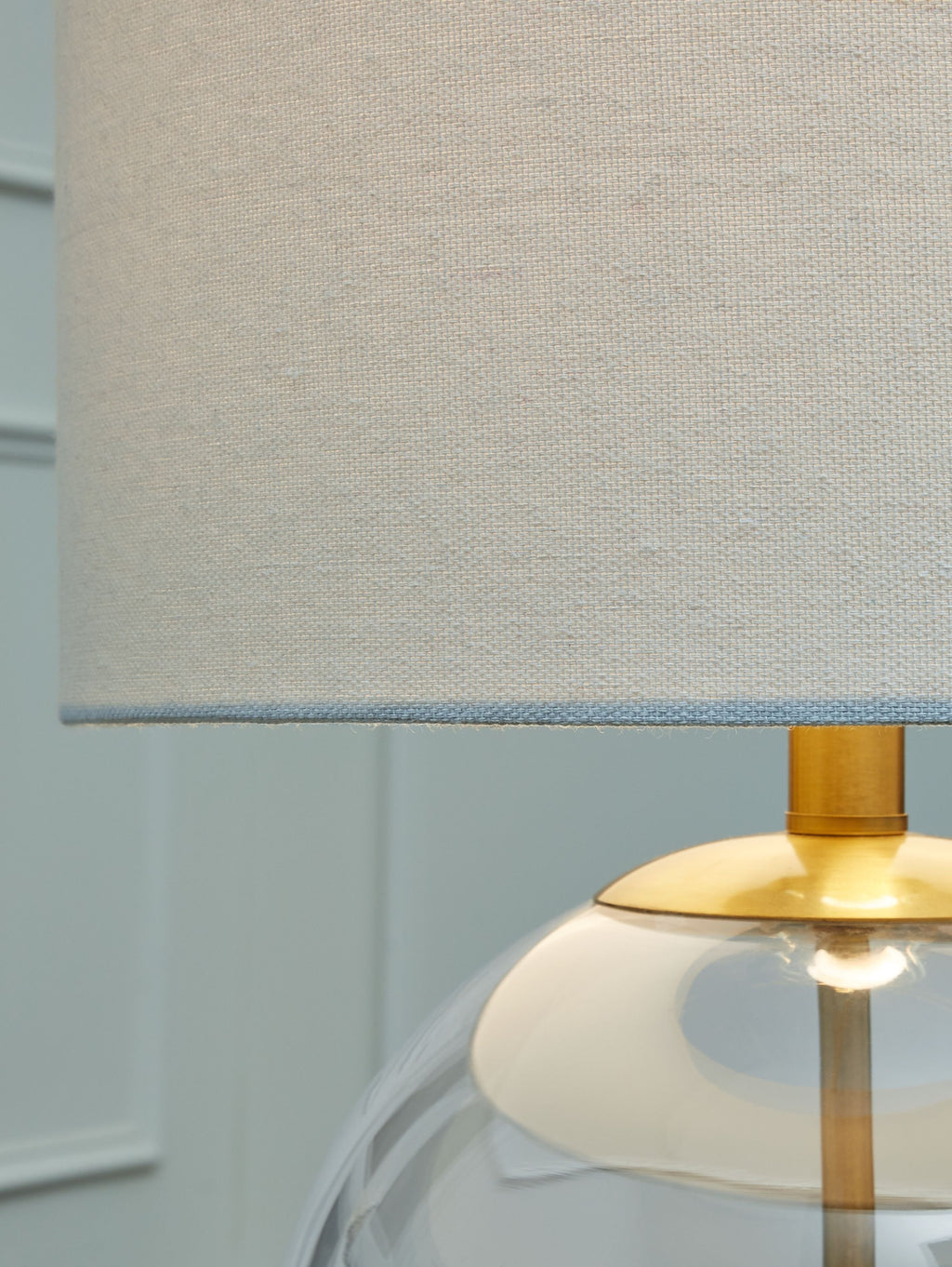 Textured white fabric lampshade with brass socket and clear glass globe edge