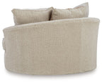 Oversized swivel accent chair side view in light beige fabric with two back pillows