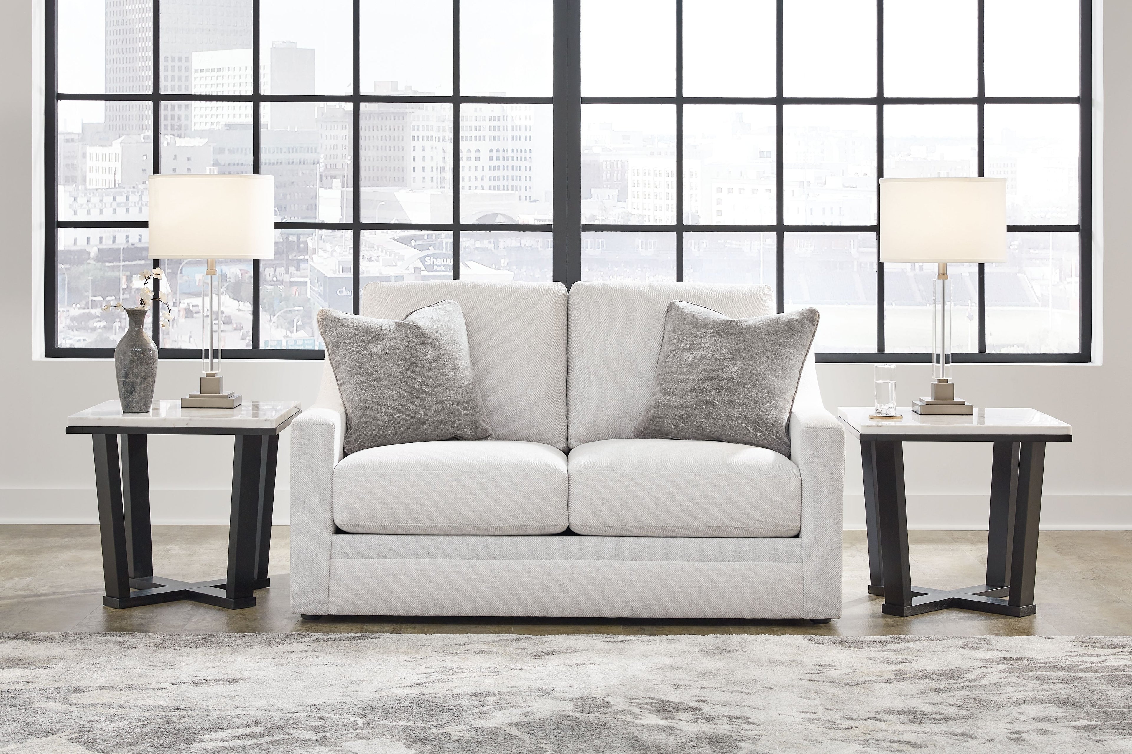 Chalk loveseat with two dark gray throw pillows, centered back and wide seat