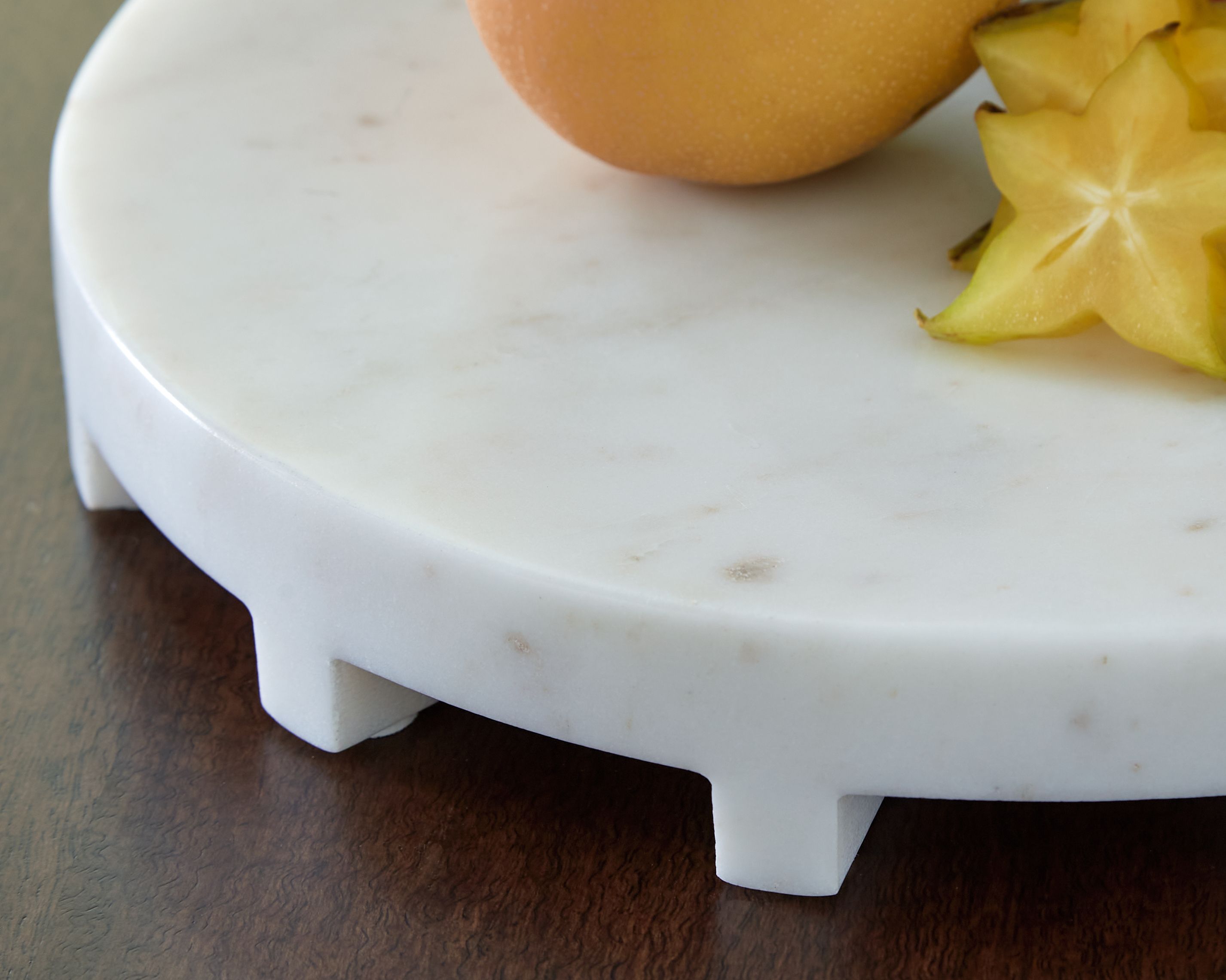 Round white serving tray, close-up of surface and short legs