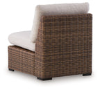Side view of dark brown woven wicker armless chair with beige cushion