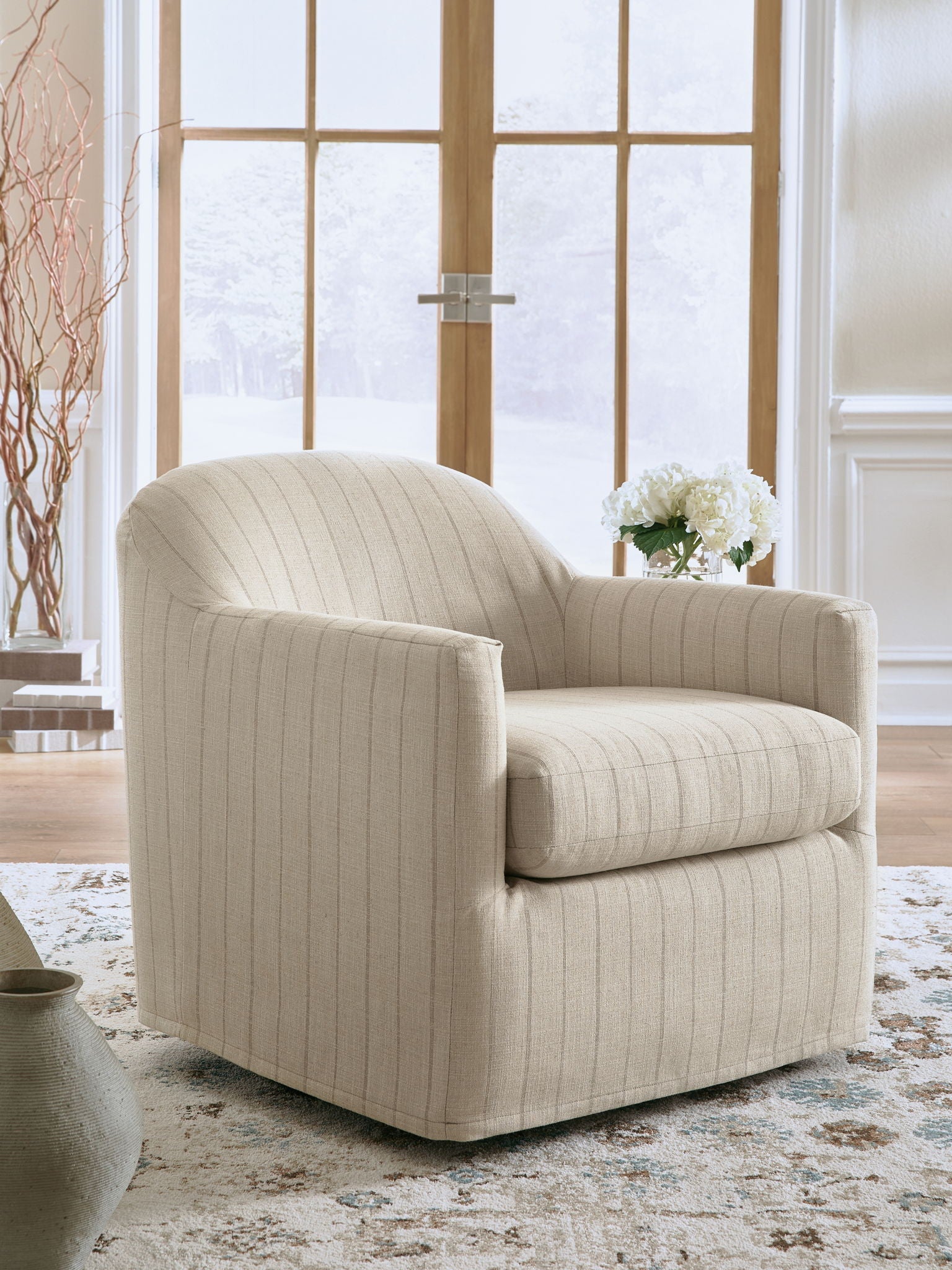 Cream swivel accent chair angled view, rounded arms and seat with vertical pinstripe.
