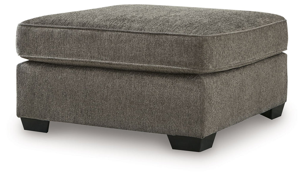 Dark gray ottoman with padded lid, rounded edges, and dark block legs
