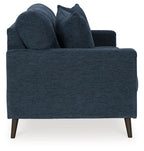 Blue upholstered sofa viewed from the side with four throw pillows