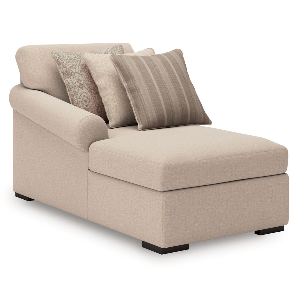 Cream upholstered chaise with three throw pillows and clean-lined armrest