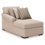 Cream upholstered chaise with three throw pillows and clean-lined armrest