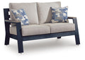 Blue patterned throw cushions on gray loveseat with armrests and two-seat cushion