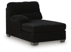 Corner chaise with dark corduroy upholstery, cushioned back, and ottoman-style seat