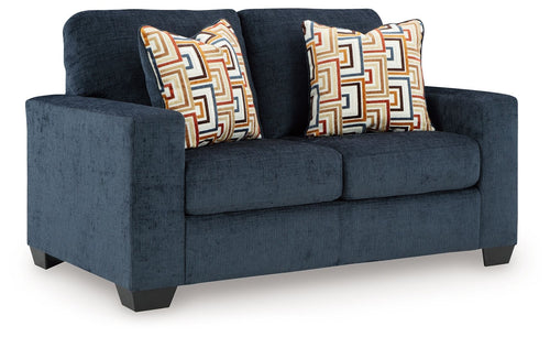 Dark navy loveseat with two decorative patterned throw pillows and boxy seat front.