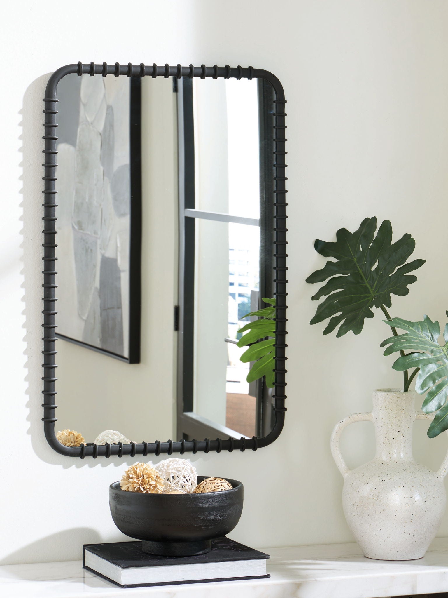 Black accent mirror with arched corners and decorative beaded trim