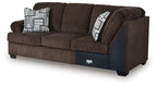 Dark brown corner wedge sectional sofa with armrests, seat cushions, and patterned pillows