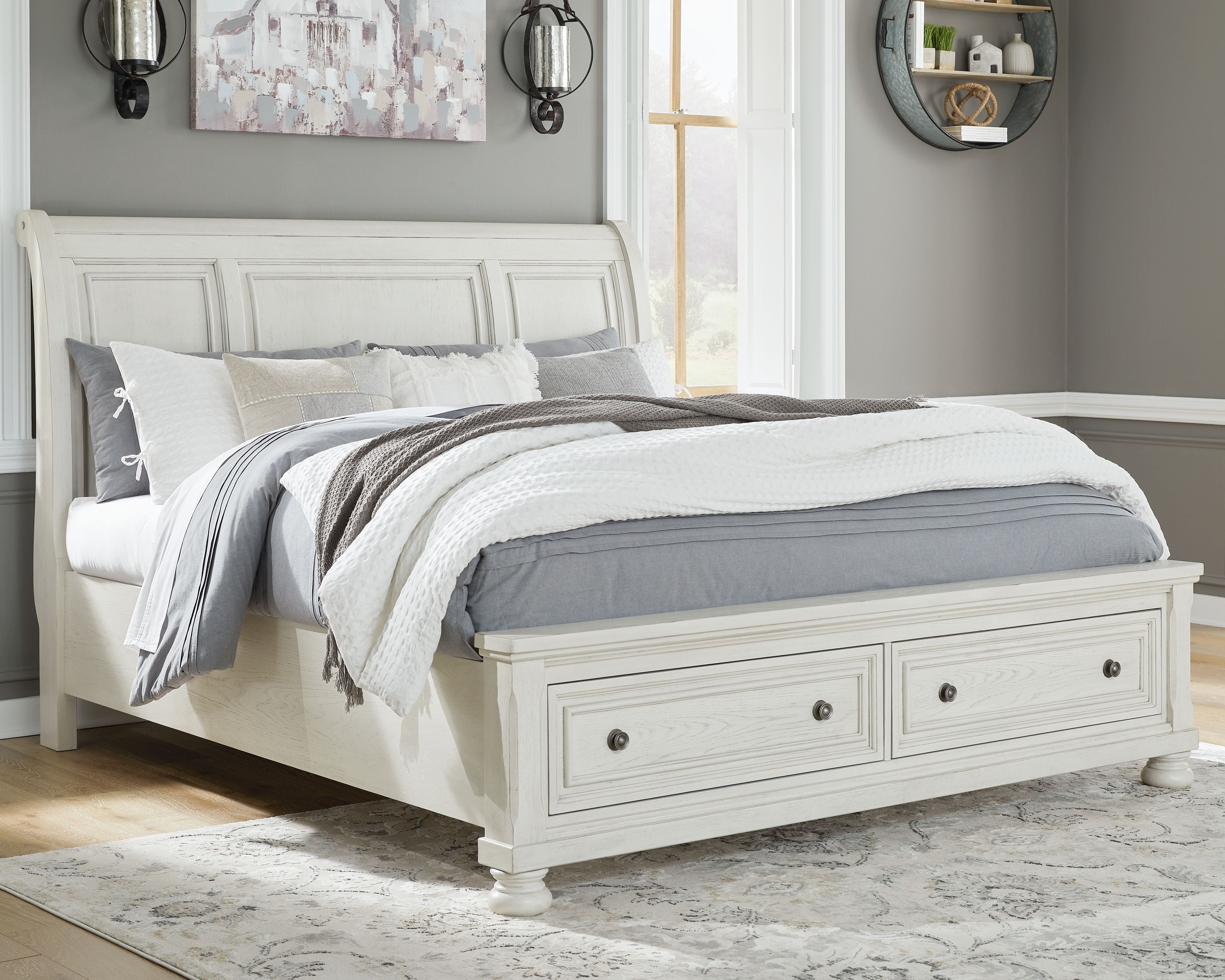 White sleigh bed with paneled headboard and footboard, styled with bedding and throw