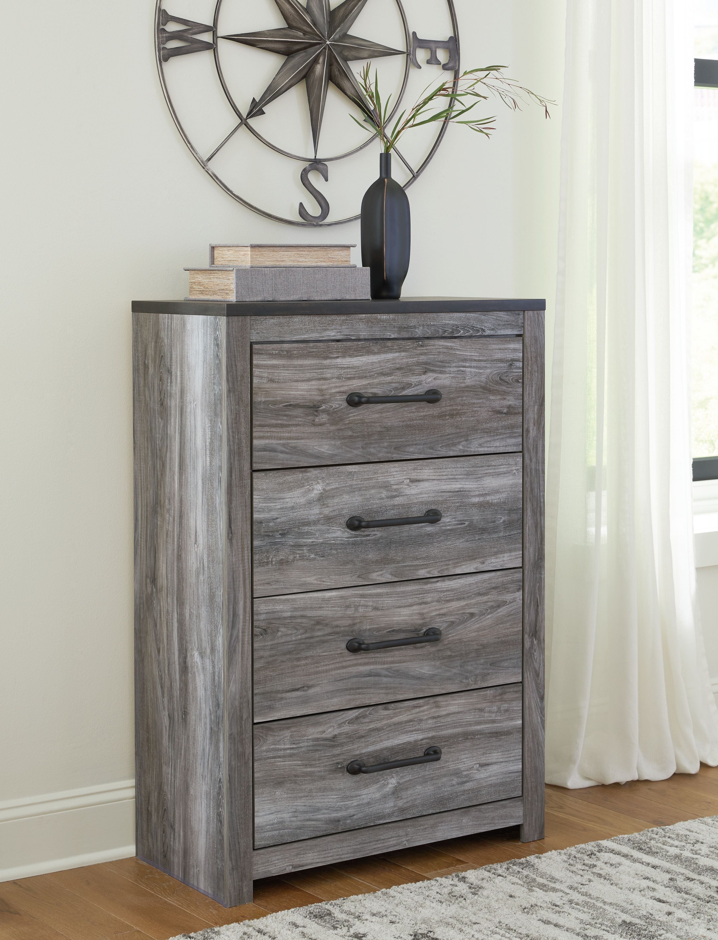 Gray wood four-drawer chest with dark bar handles and square tapered legs