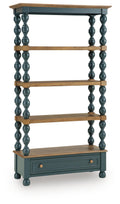Blue bookcase with brown shelves, turned posts, and a drawer cabinet at the base.