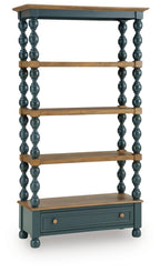 Blue bookcase with brown shelves, turned posts, and a drawer cabinet at the base.