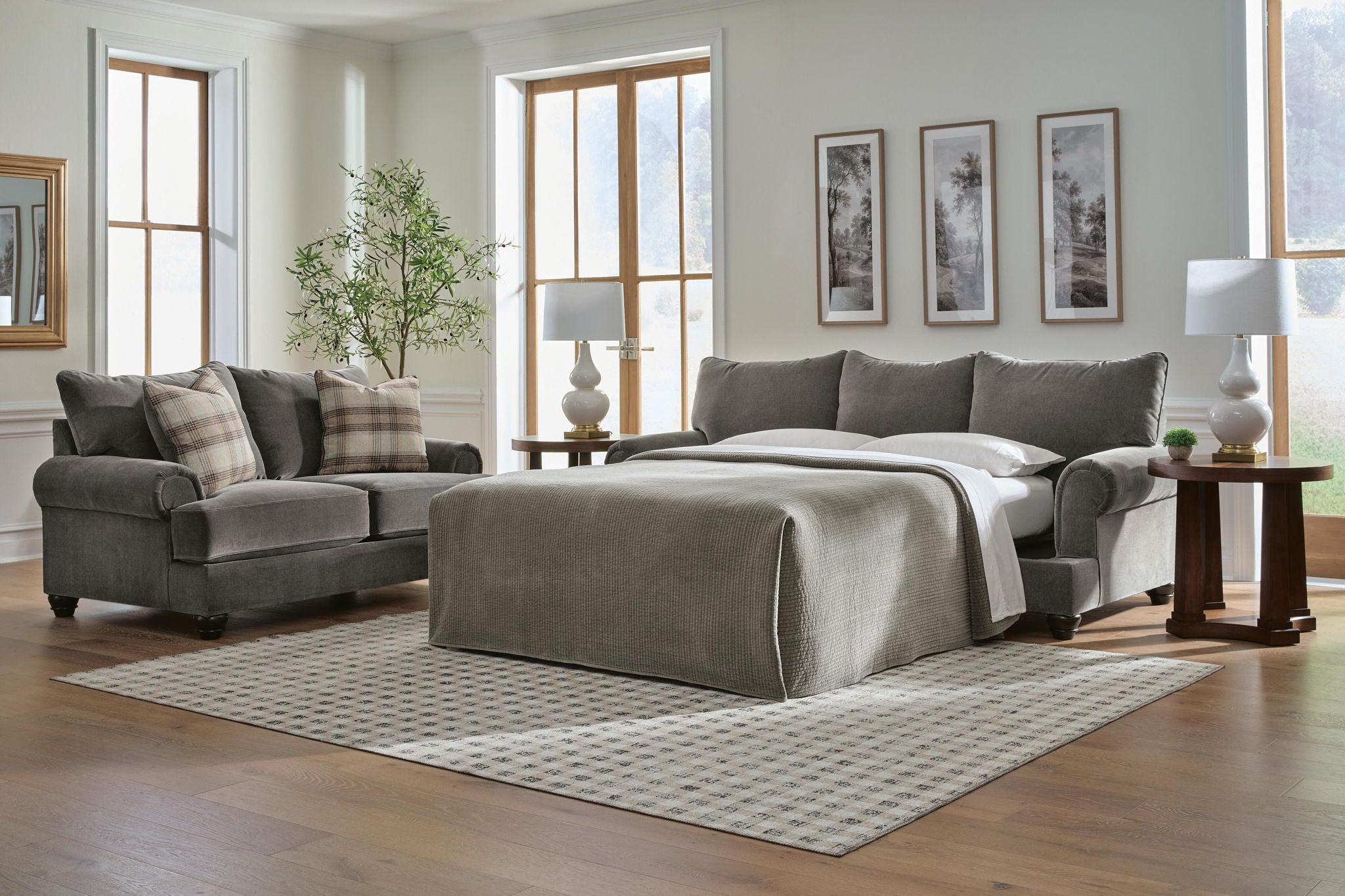 Gray sofa sleeper with pull-out mattress extended and matching throw pillows