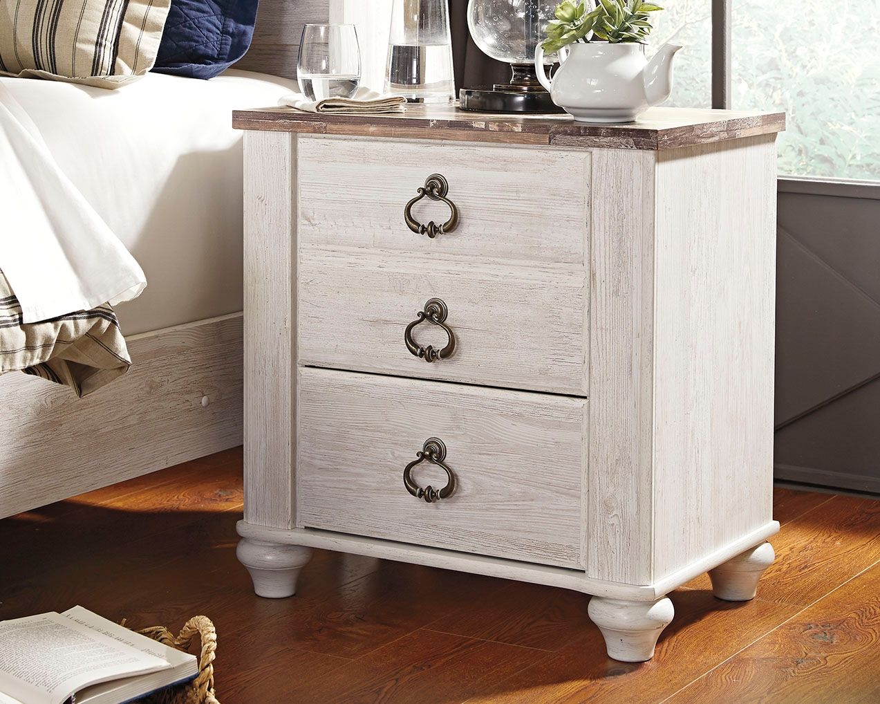 White distressed wood nightstand with three drawers and dark bronze drawer pulls