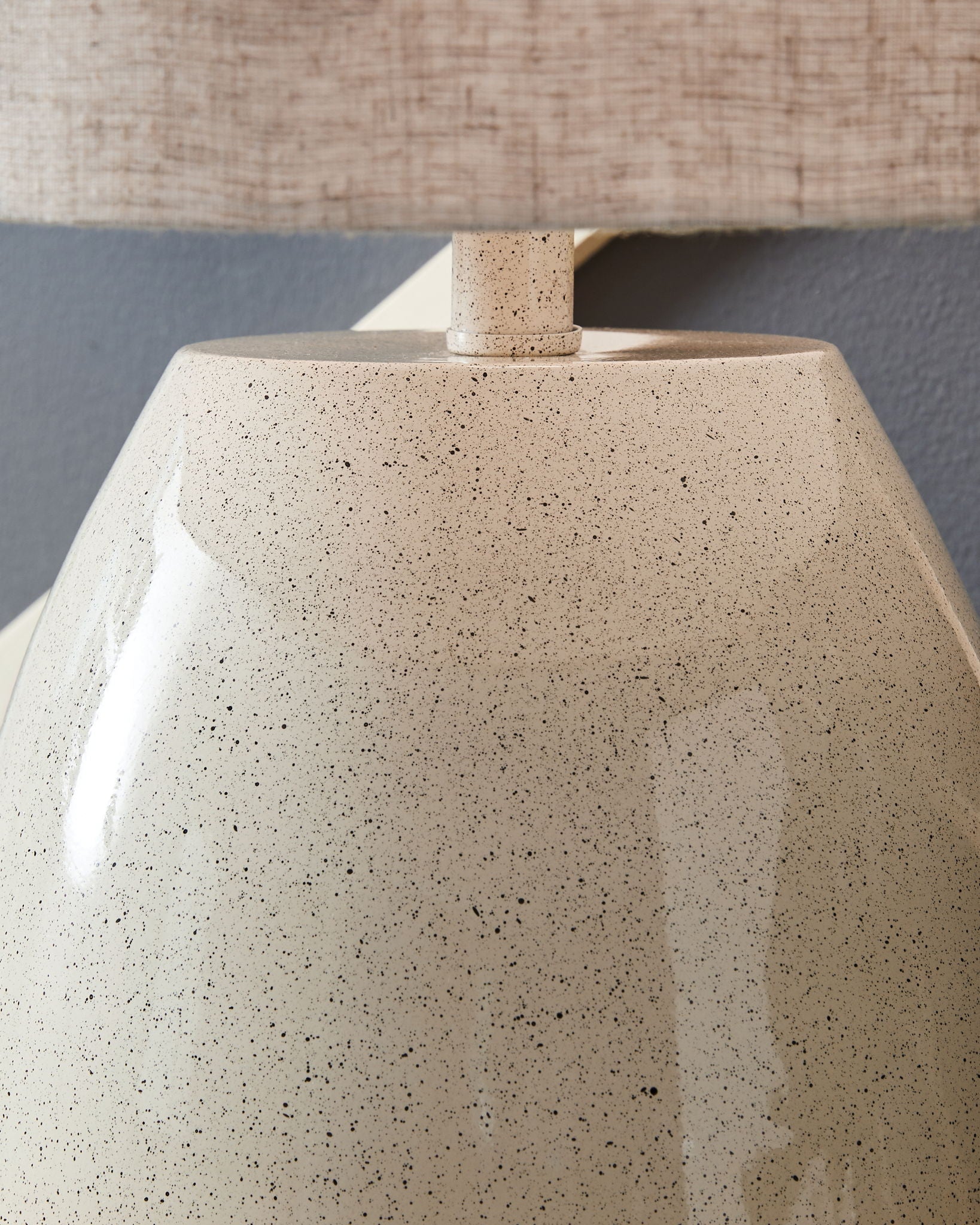 Speckled beige lamp base with small neck and linen drum shade top
