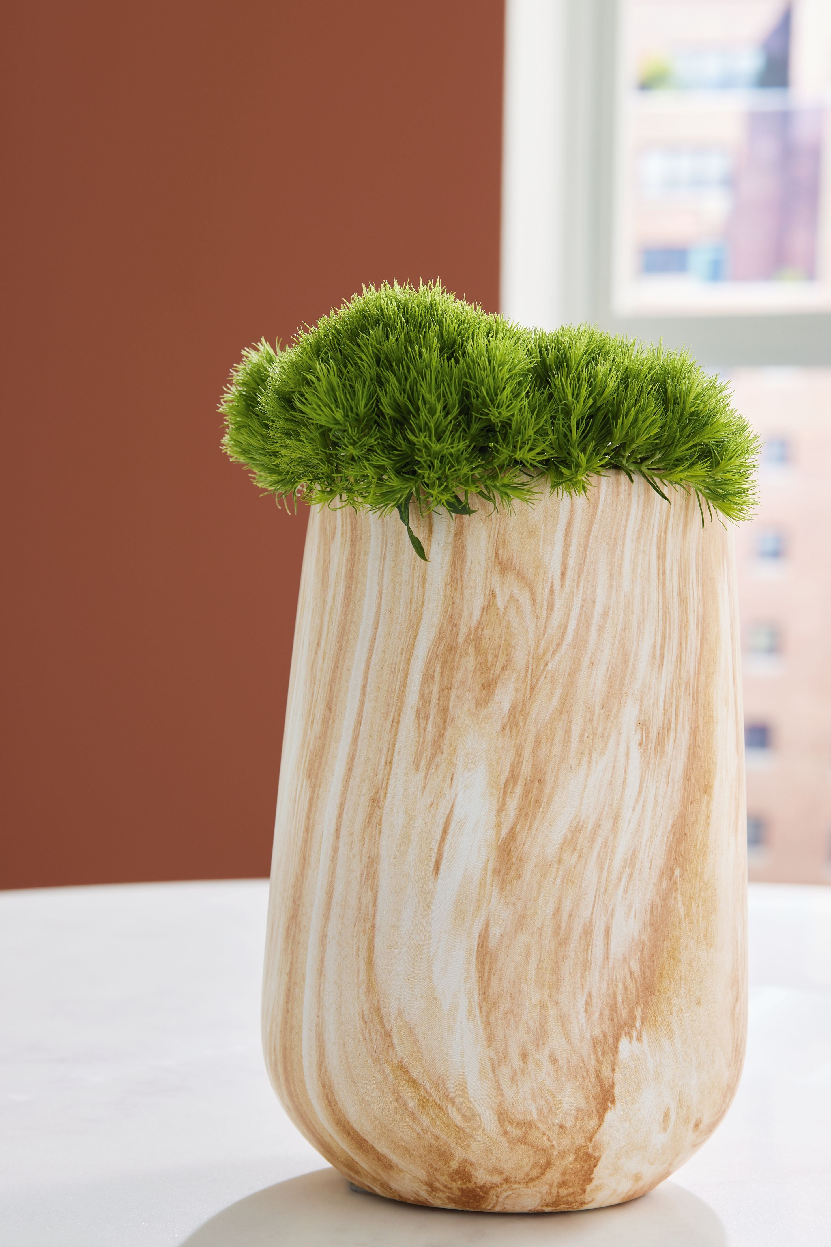 Beige marbled vase with dense green foliage, wide open top and rounded body