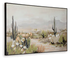 Framed wall art with cactus silhouettes and white flowers over sandy desert landscape