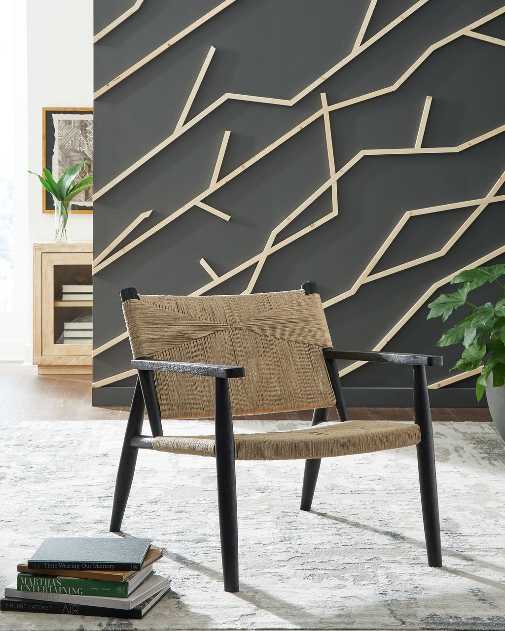 Accent chair with black wooden frame and arms, natural woven seat and backrest