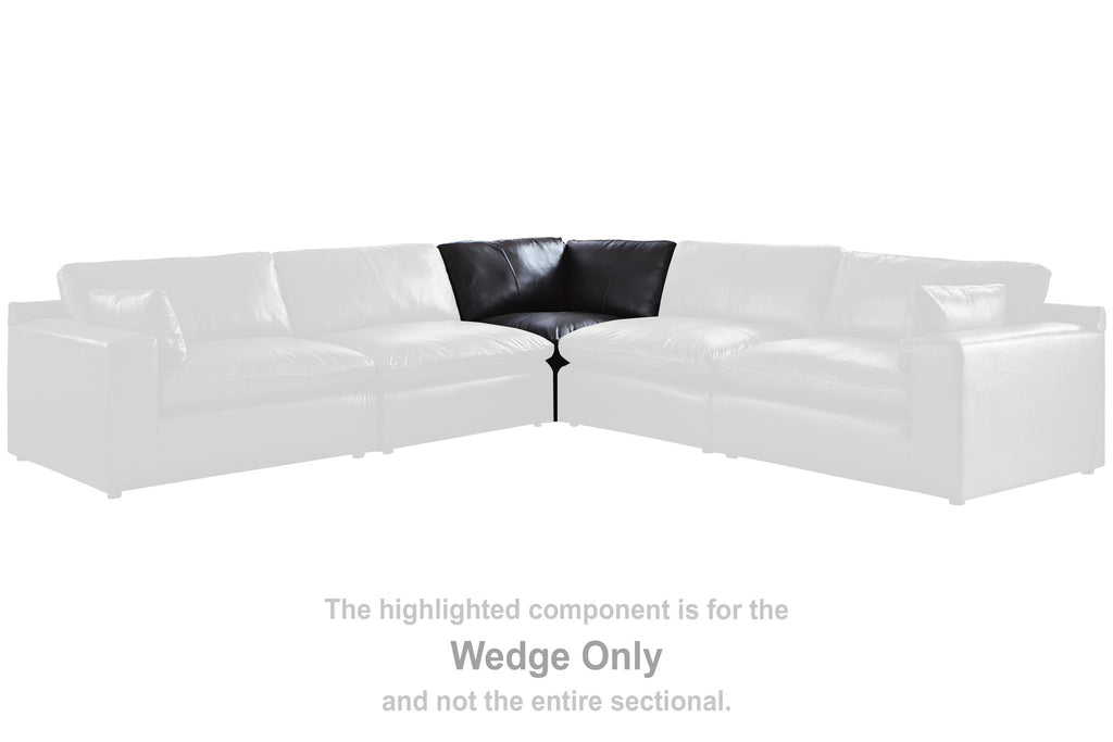 Black wedge sofa section with armrests and padded seat cushions
