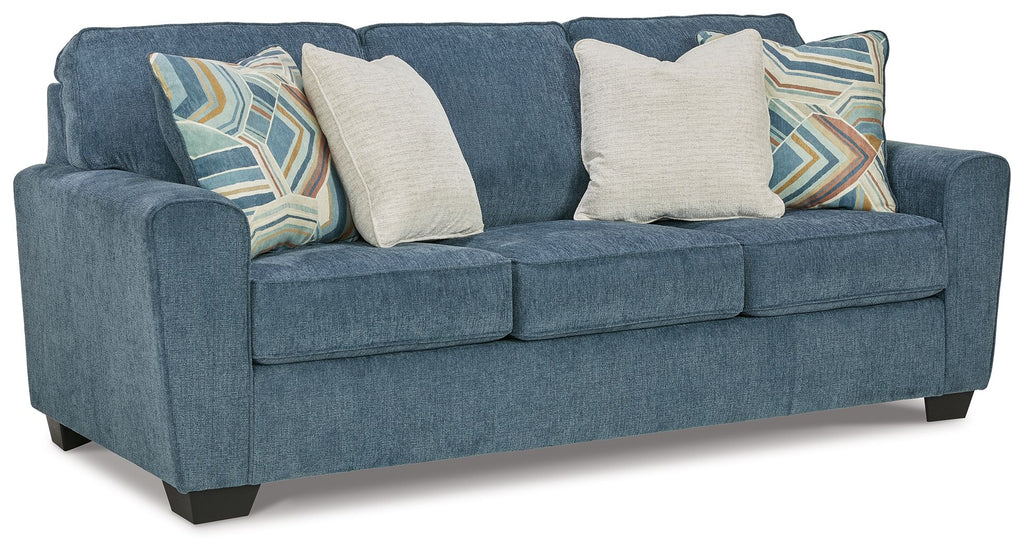 Blue fabric sofa with three seat cushions and decorative throw pillows