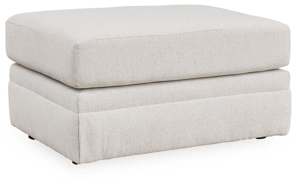 Light beige fabric ottoman with cushioned top, smooth sides, short dark legs