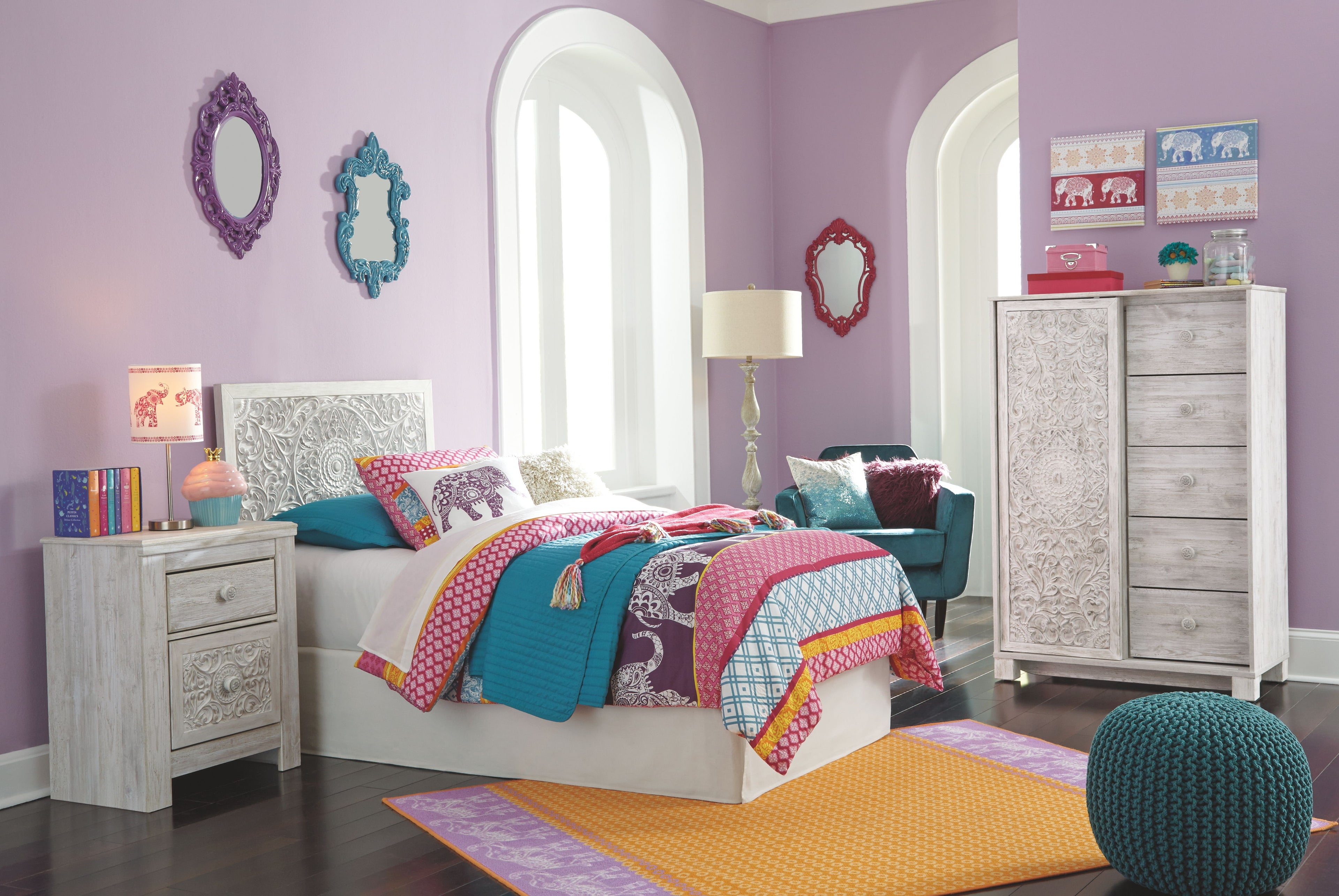 Twin bed with whitewash paneled headboard and colorful patchwork bedding